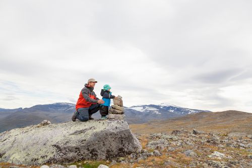 father and son next to a cairn