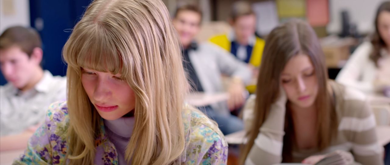 Highschool students sit at desks in a classroom