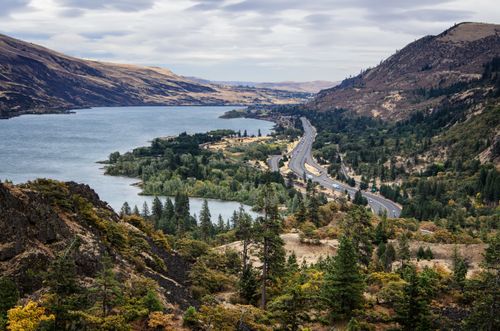 An aerial view of the Columbia River in Oregon, with a highway running alongside the river.