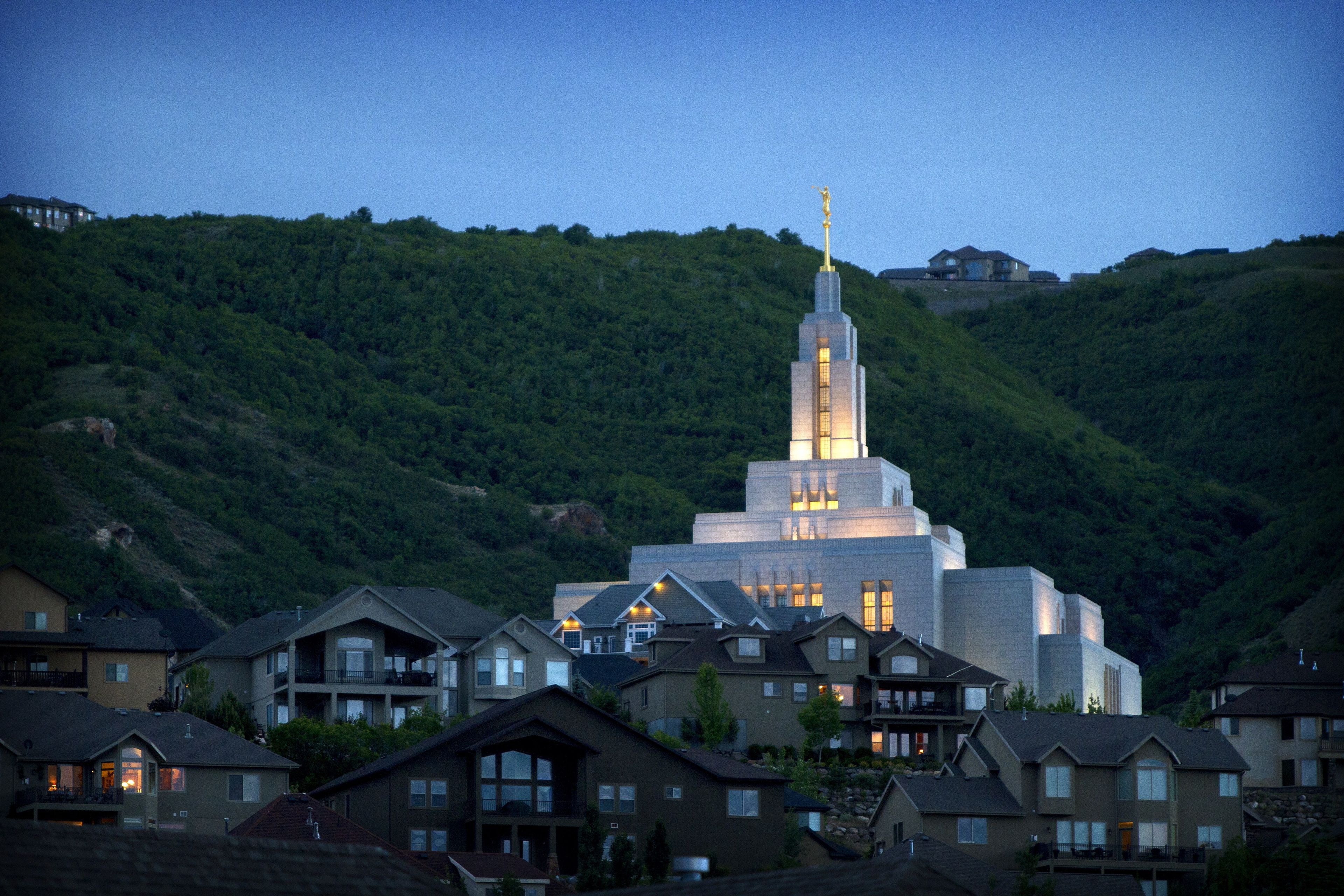 A view of the Draper Utah Temple from the nearby neighborhood at night.