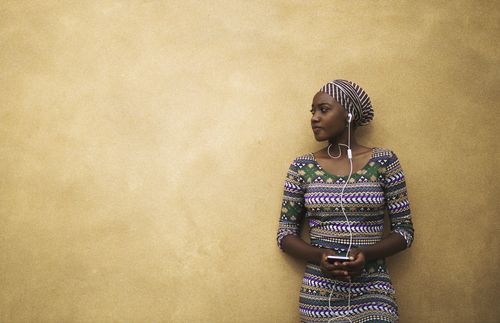 young African woman listening to music and looking sideways