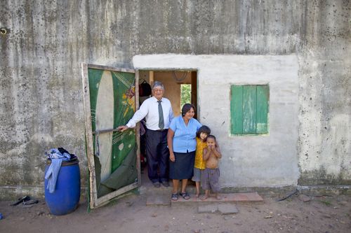 family standing at the door of their home