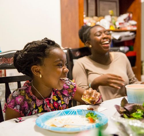 sisters laughing and eating dinner