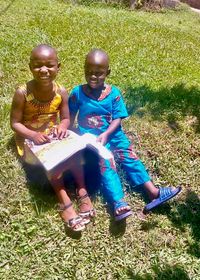 two children in bright clothes reading Friend magazine together