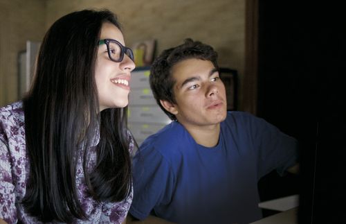 young woman and young man looking at computer screen