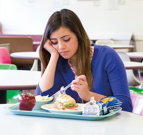 una mujer mirando la comida en el plato