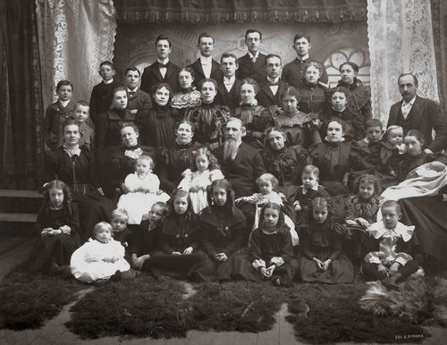 A large group portrait of Joseph F. Smith with his five wives and children, taken on his 60th birthday in November 1898.