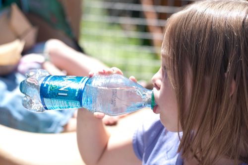 girl drinking from a water bottle