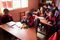 Young children are in a classroom. There are chairs and tables around the room. Various children are working out of books. This is in El Alto, Bolivia.