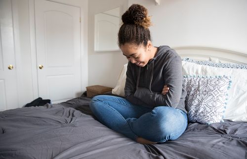 woman sitting on bed and praying