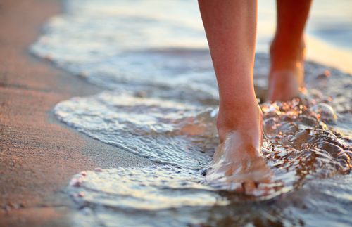 feet walking on a beach