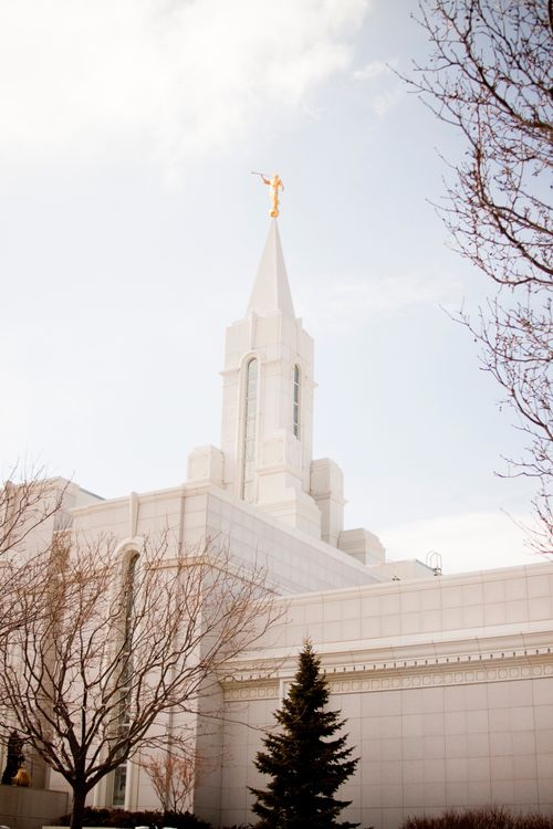 A front side view of the Bountiful Utah Temple on a sunny winter day, with bare trees on the temple grounds.