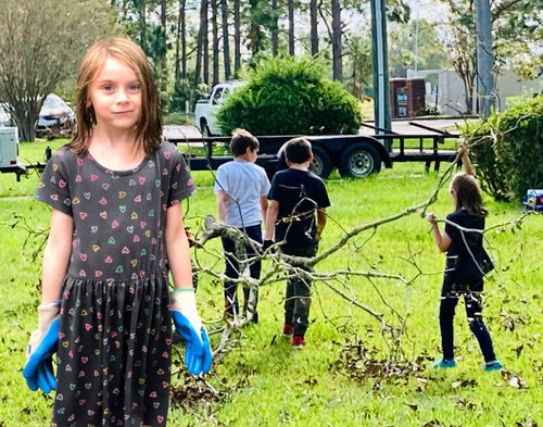 girl helping move branches