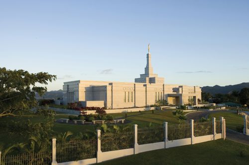 The Suva Fiji Temple in the late afternoon, with the grounds and fence in the foreground.