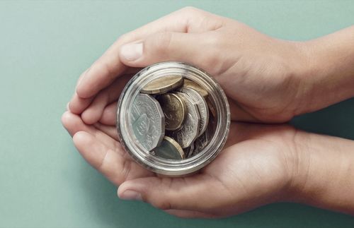 person holding jar of coins