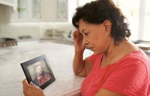 a woman looking at a picture of the Savior