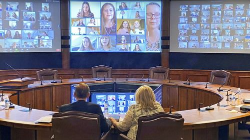 Elder and Sister Stevenson in front of large video chat screen