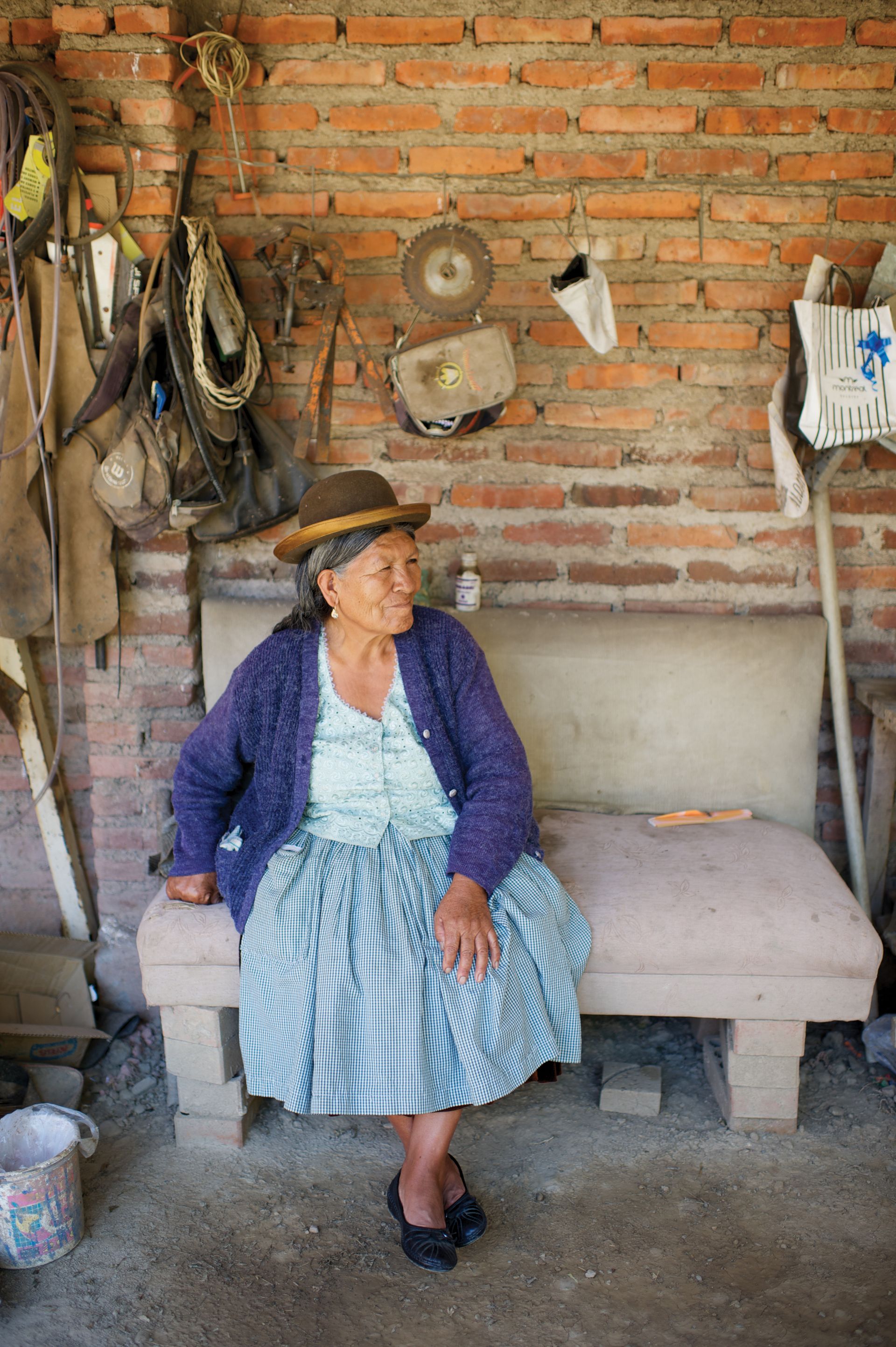 An elderly woman in Bolivia sitting on a bench.
