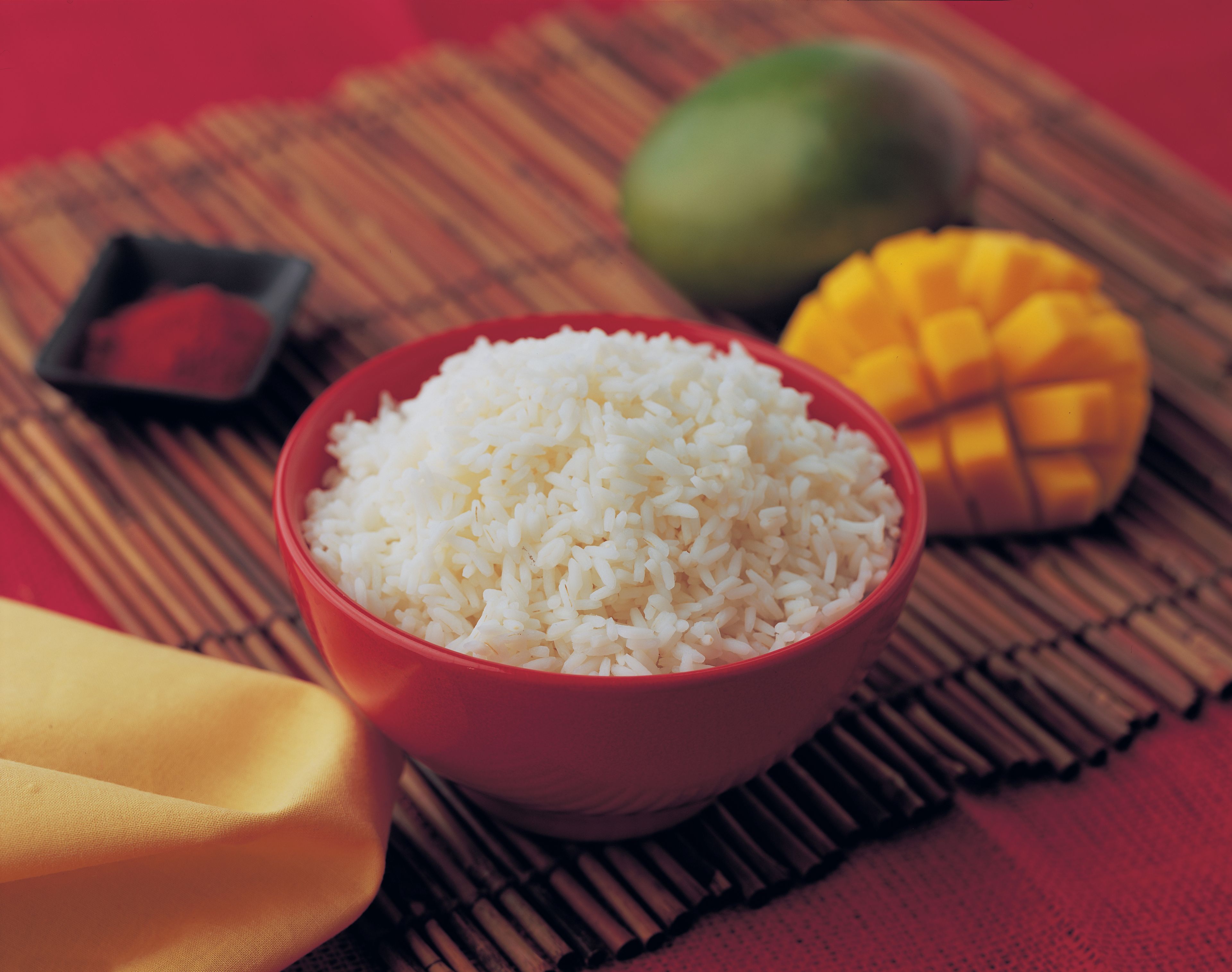 A bowl with rice and cut mangoes.