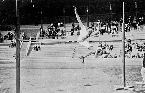 man jumping over a bar in athletic event