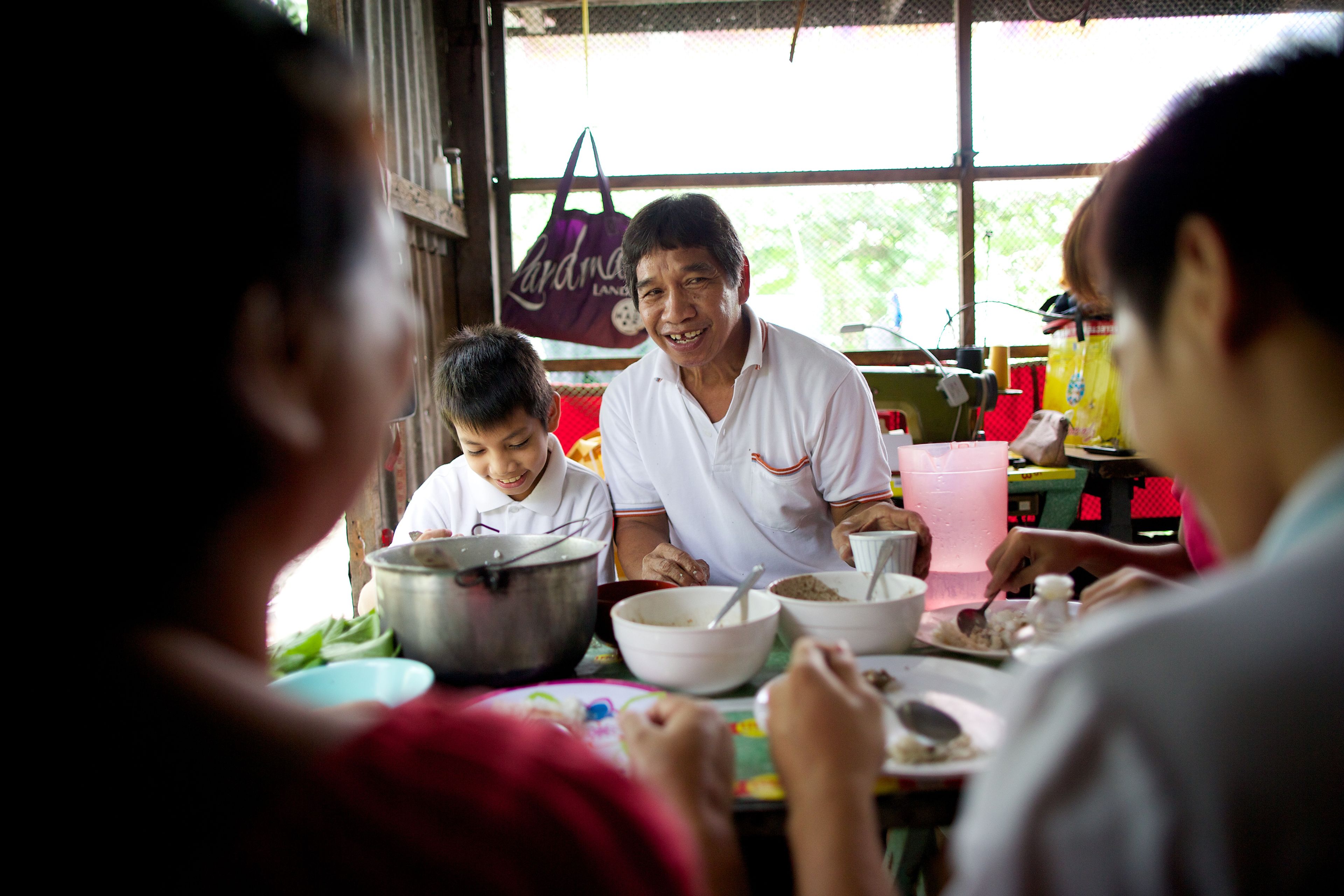 A father sits at the dinner table surrounded by his family.