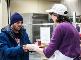 person providing food for homeless person