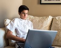 youth typing on laptop