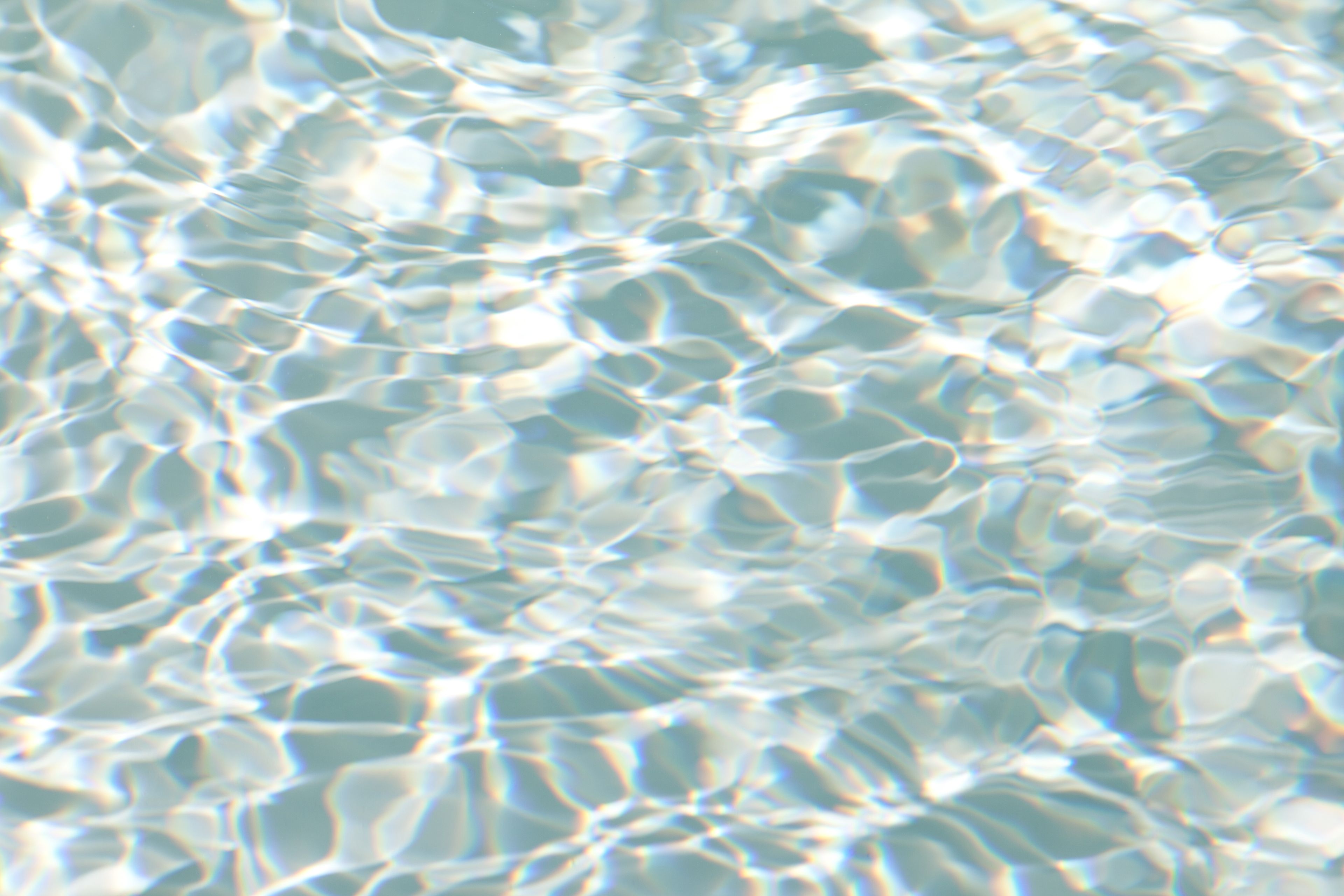 Small waves in a pool of clear blue water.