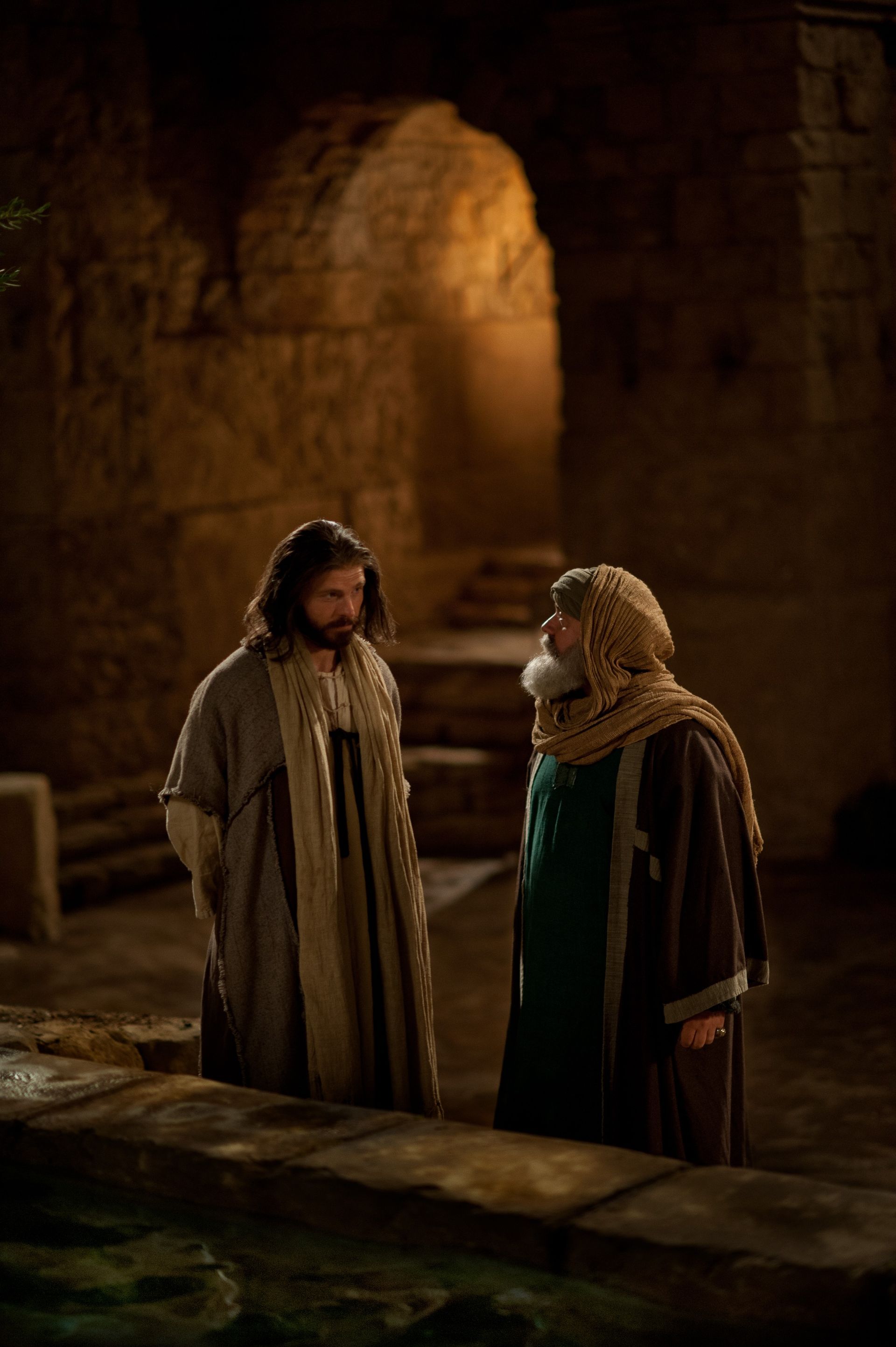 Jesús habla con Nicodemo junto a un estanque de agua.
