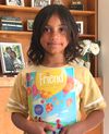 Una niña sosteniendo la revista El Amigo