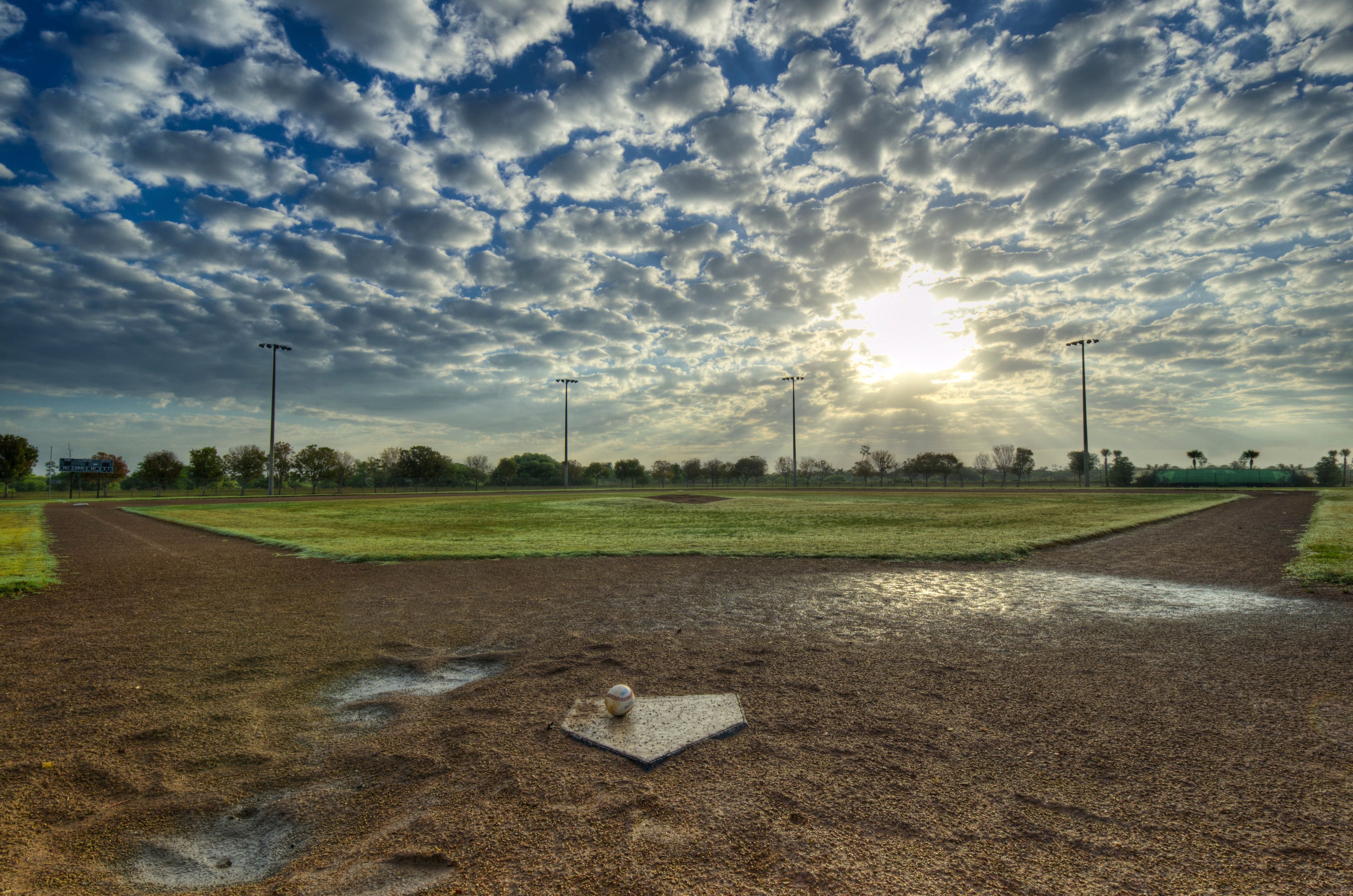 The sun rises over a baseball field.  