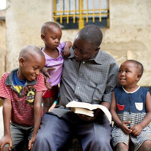 a man reading with his three children