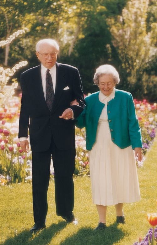 President and Sister Hinckley walking through a garden together.