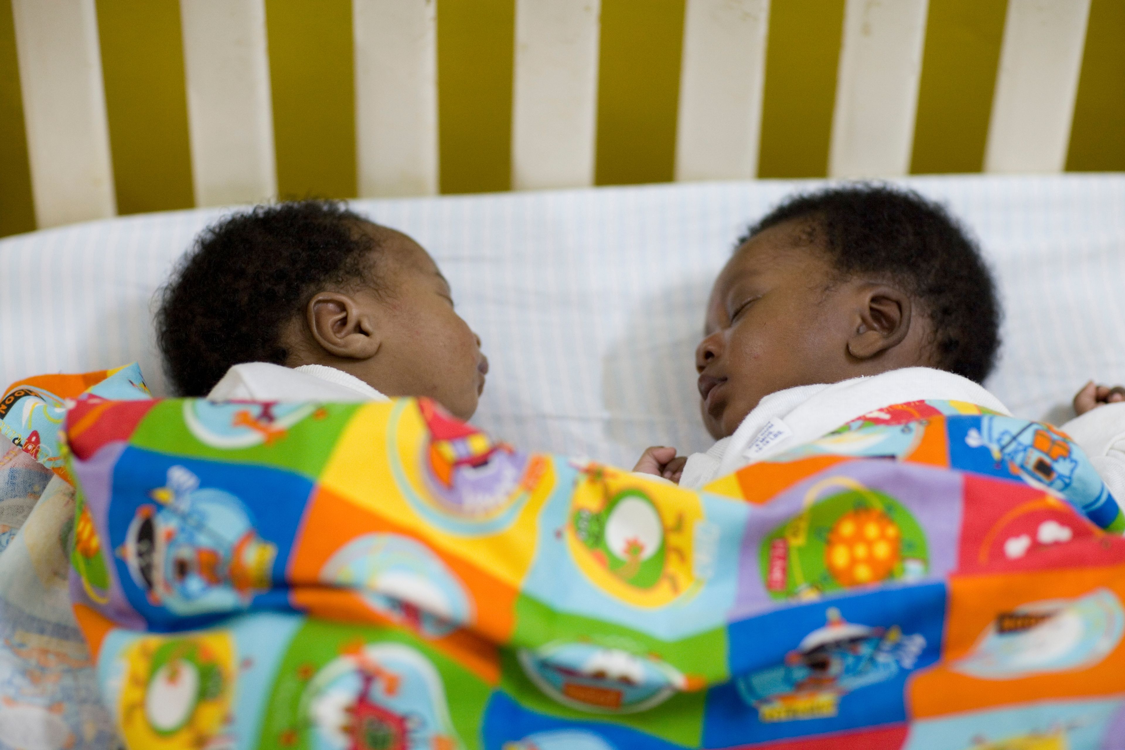 Twin boys from Ghana sleeping next to one another.