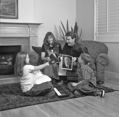 Family studying pictures of Joseph Smith and President Hinckley