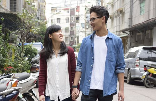 young woman and young man holding hands