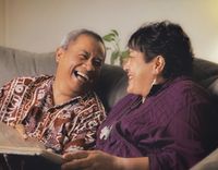 Polynesian couple on a couch with a photo album.