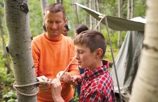 a father and son putting up a tent