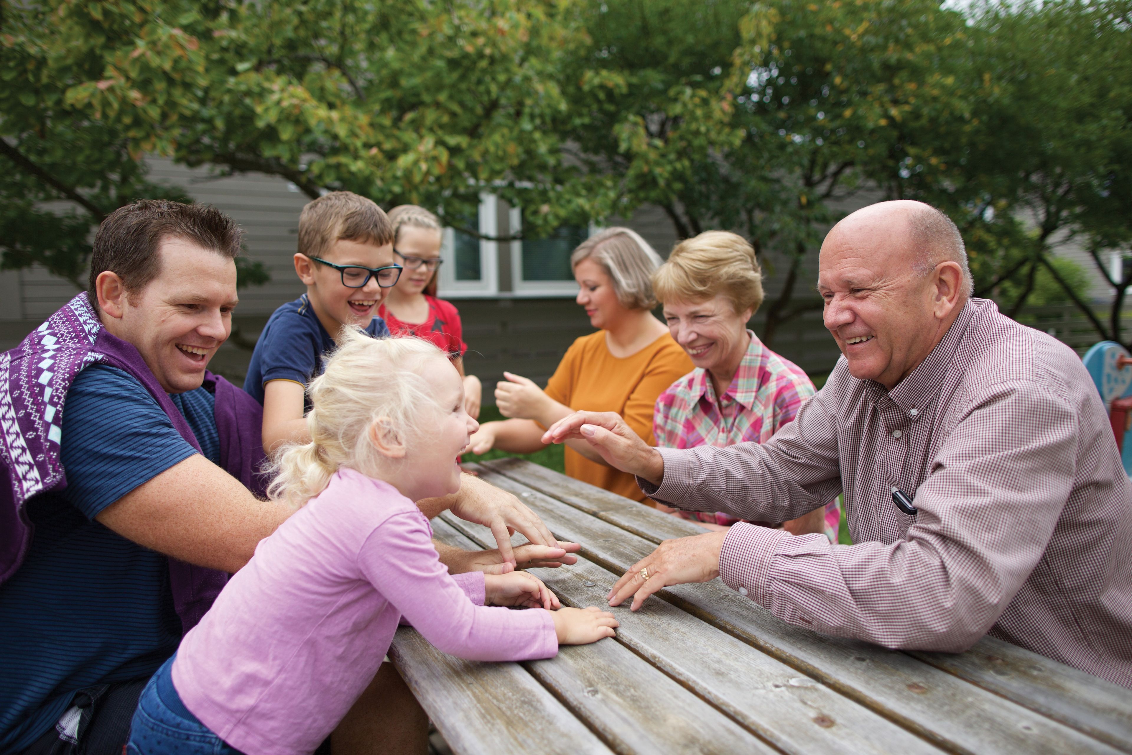 Several generations of a family sit at a picnic table in Norway.