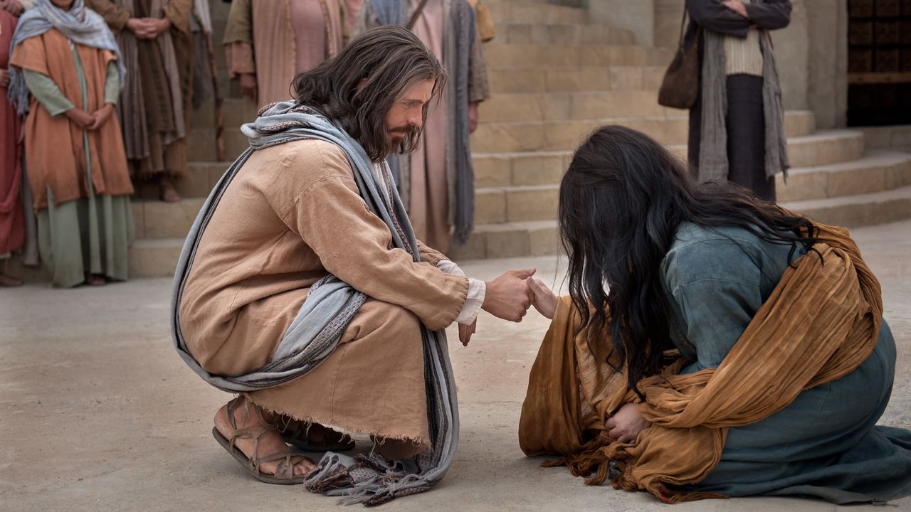 Jesus raises a woman by the hand