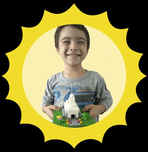 Headshot of a little boy holding a block temple