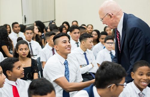 President Dallin H. Oaks schudt een jongeman de hand