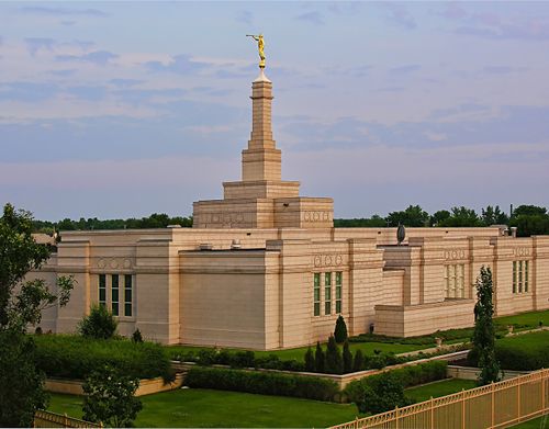The Montreal Quebec Temple amid green grass, with the temple’s fence seen in the bottom right corner.