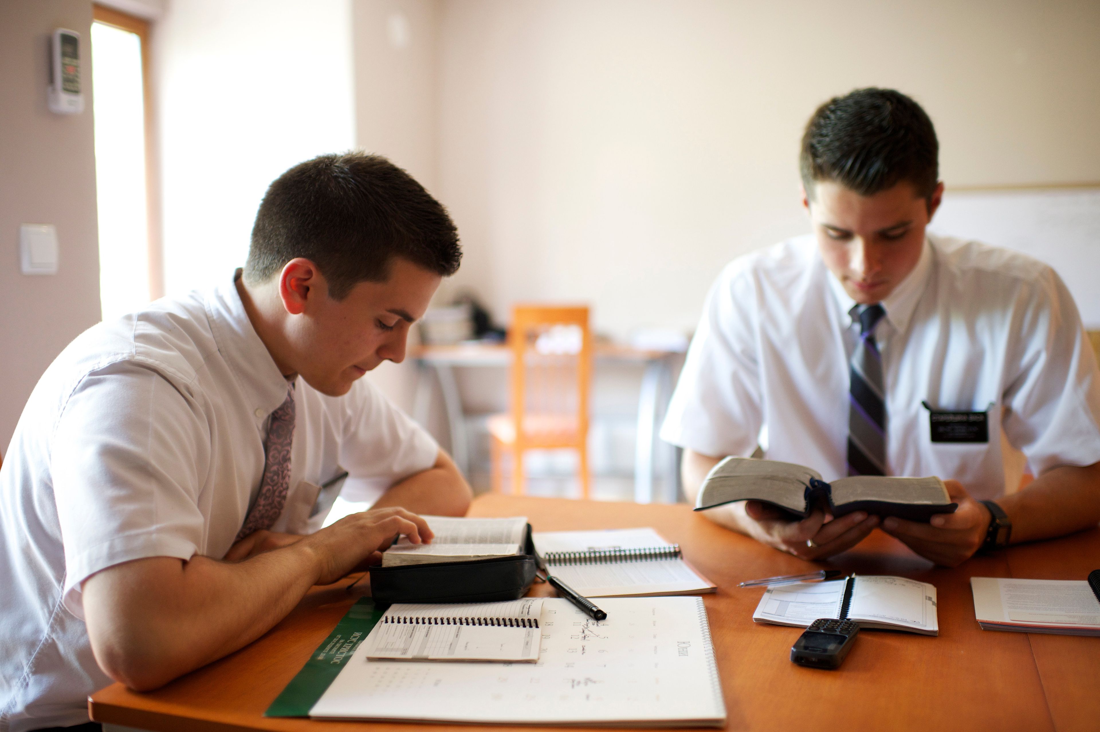 Two missionaries read the scriptures together.