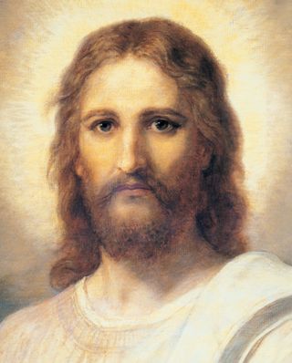 Frontal head and shoulders portrait of Jesus Christ. Christ is depicted wearing a pale red robe with a white and blue shawl over one shoulder. Light emanates from the face.