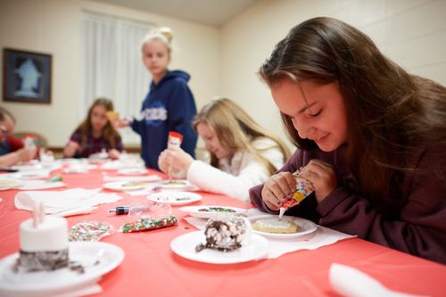 Various youth are together in an LDS Meetinghouse. They are cooking and decorating cookies. This is in Baton Rouge, Louisiana.