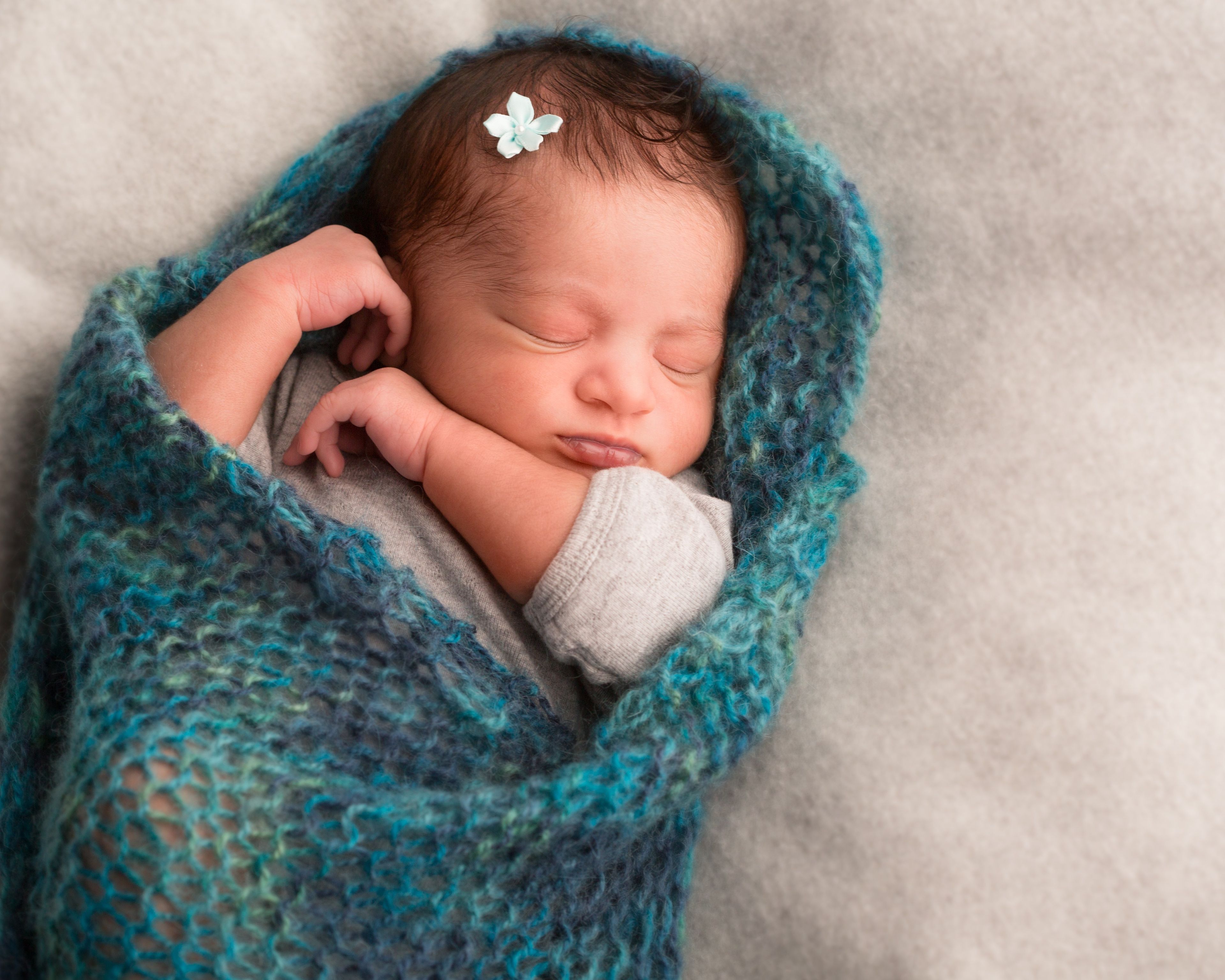 A newborn girl sleeping in a blanket.