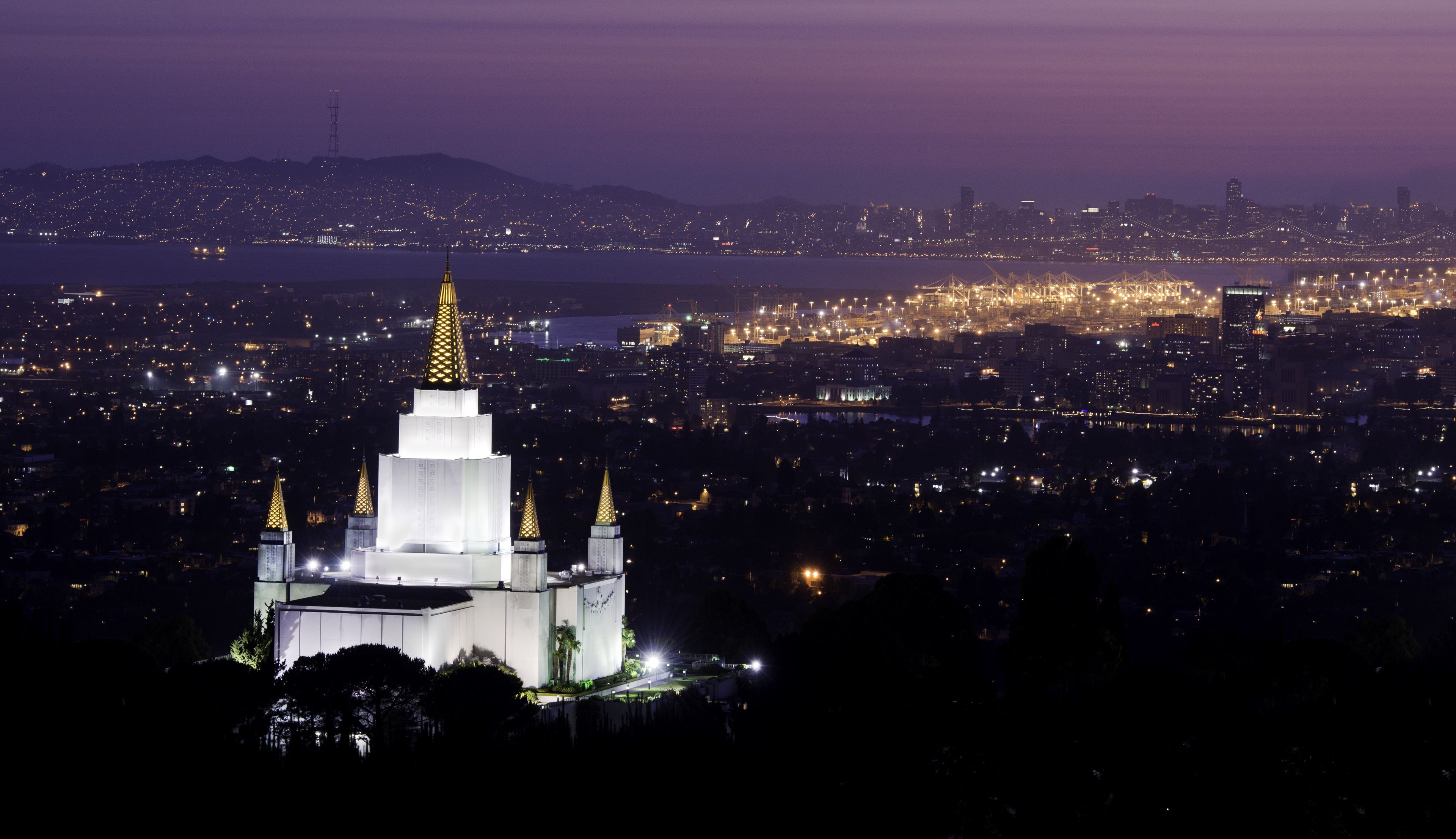 The Oakland California Temple in the evening, including the city.