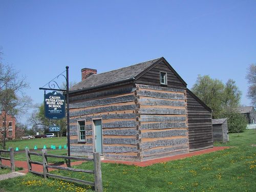 A log cabin with a blue door, known as the Pendleton home and schoolhouse, in Nauvoo, Illinois.