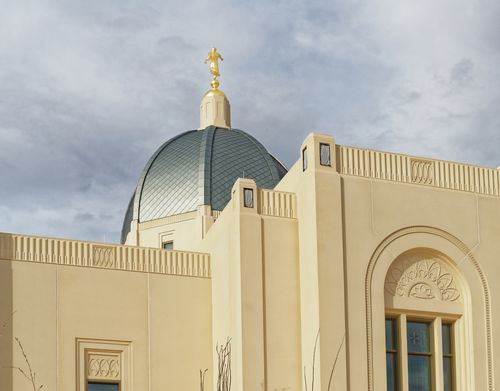 A low-angle photograph of the Tucson Arizona Temple showing the dome and details of the walls and windows.